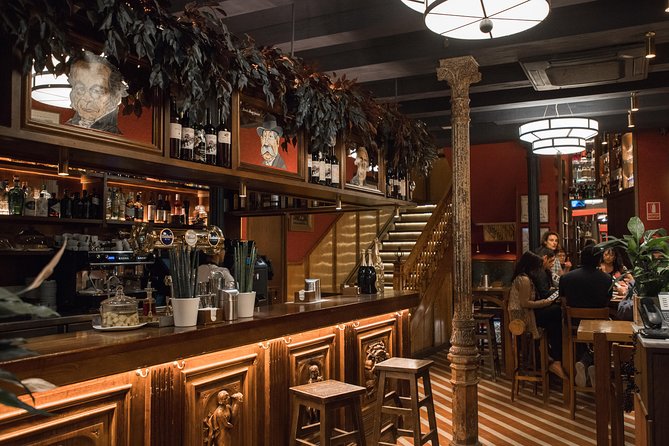 A long wooden bar counter and stools, lit and empty before opening